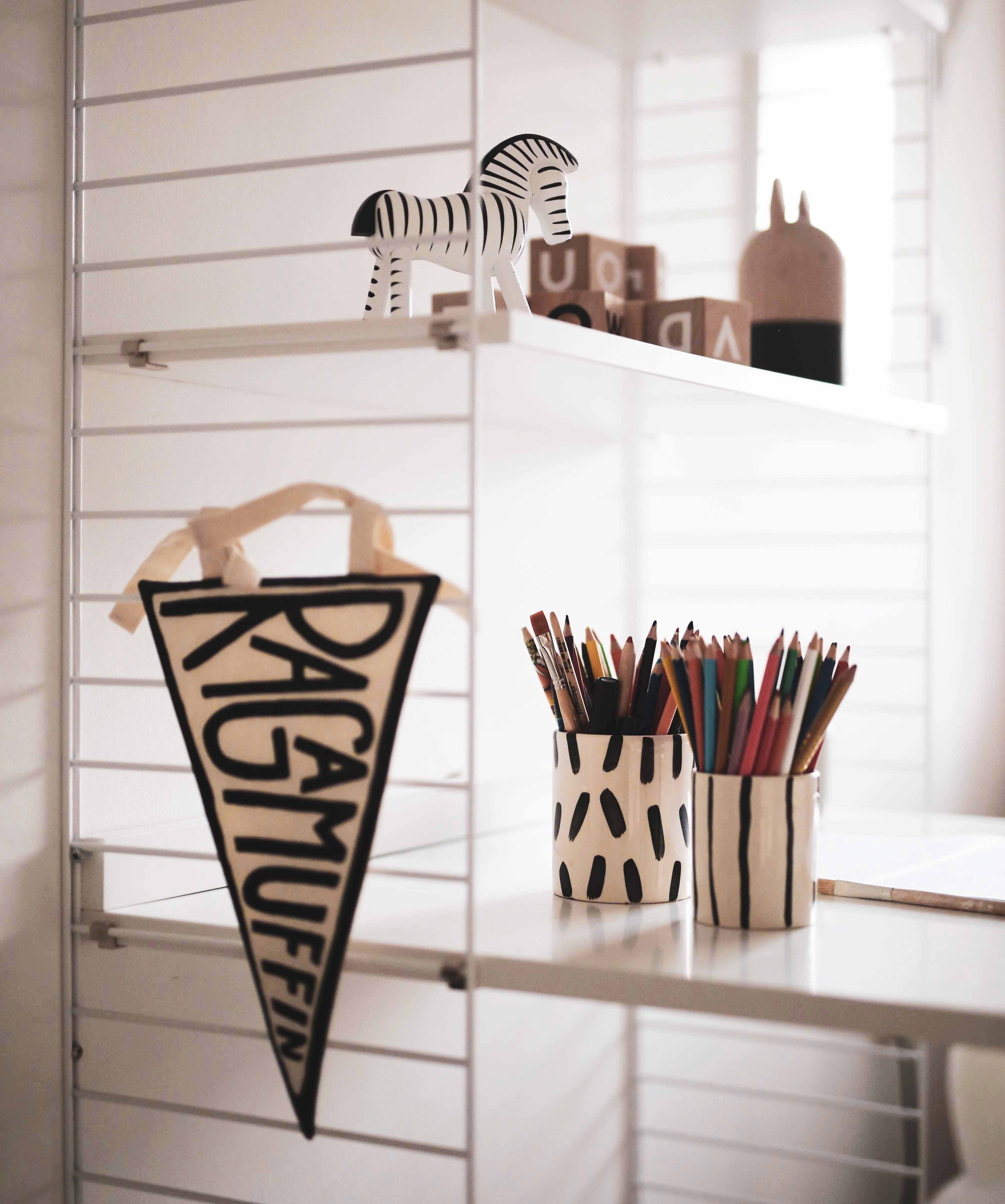 Shelving unit in a girl’s room with ooh noo blocks and mugs