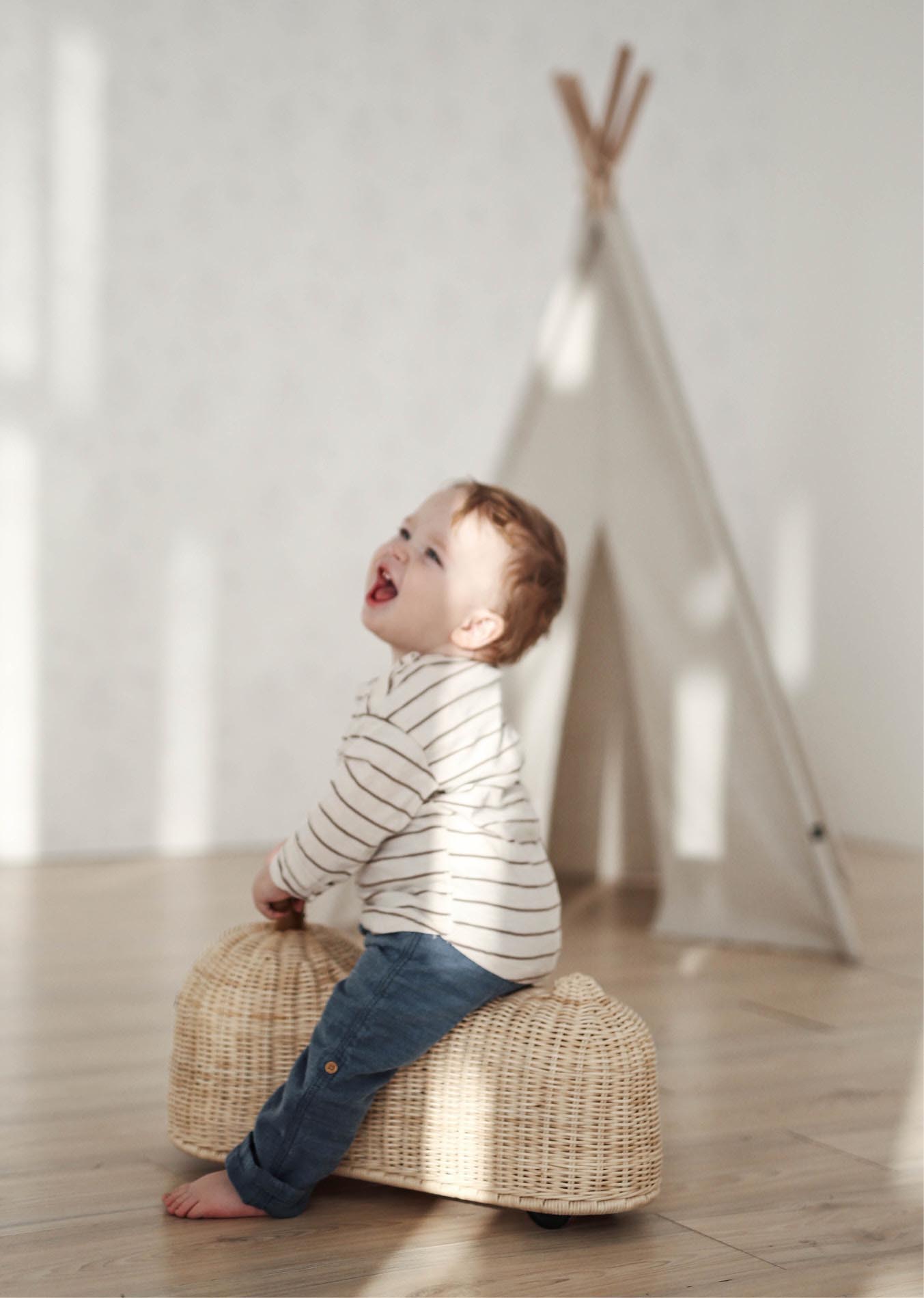 Children’s Ride-On Toys That Inspire Creativity and Movement_5 Child playing with Ride On Toy made of Rattan